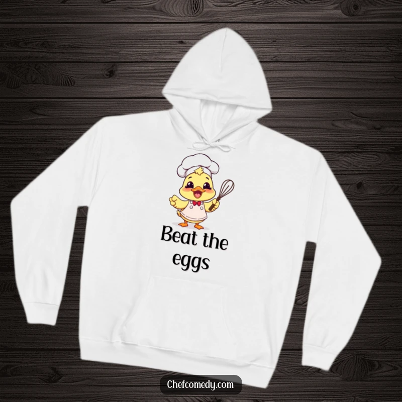 Funny duck chef with apron and whisk, looking excited, featured on a cozy hoodie for warmth and inspiration.