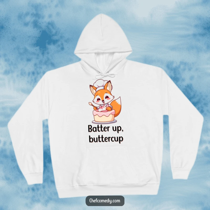 Cute, funny fox chef wearing an apron, passionately frosting a layered cake with a charming smile on a hoodie.