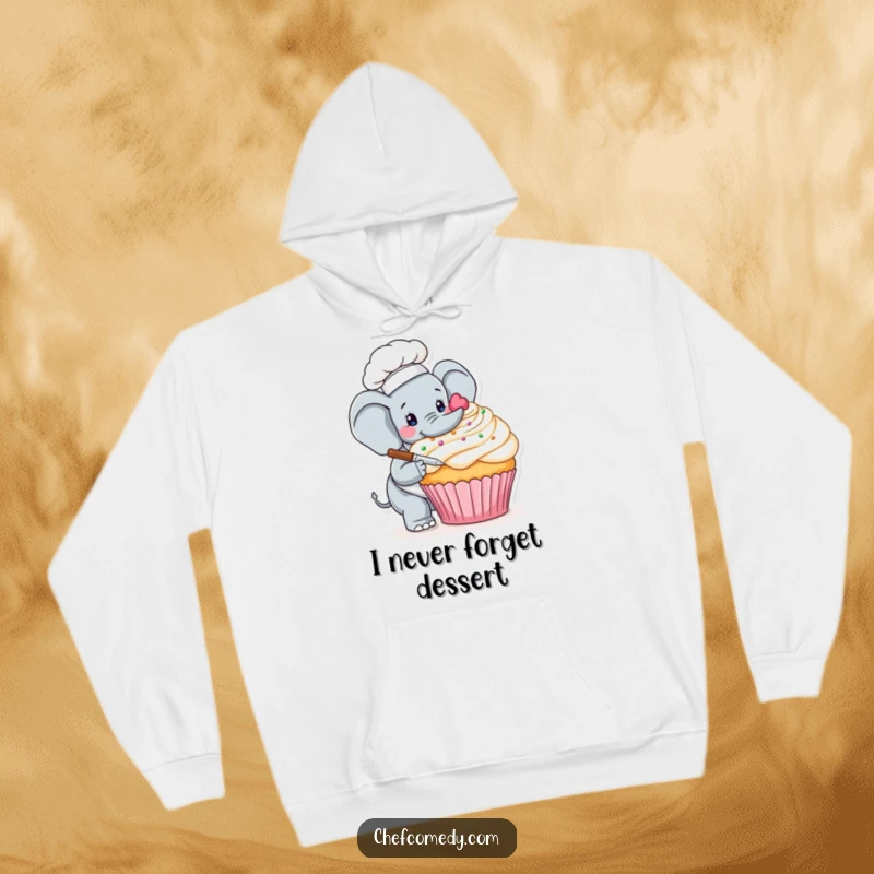 Funny hoodie depicting a careful elephant chef delicately adorning a giant cupcake with colorful frosting and sprinkles, ideal for cozy treat lovers.