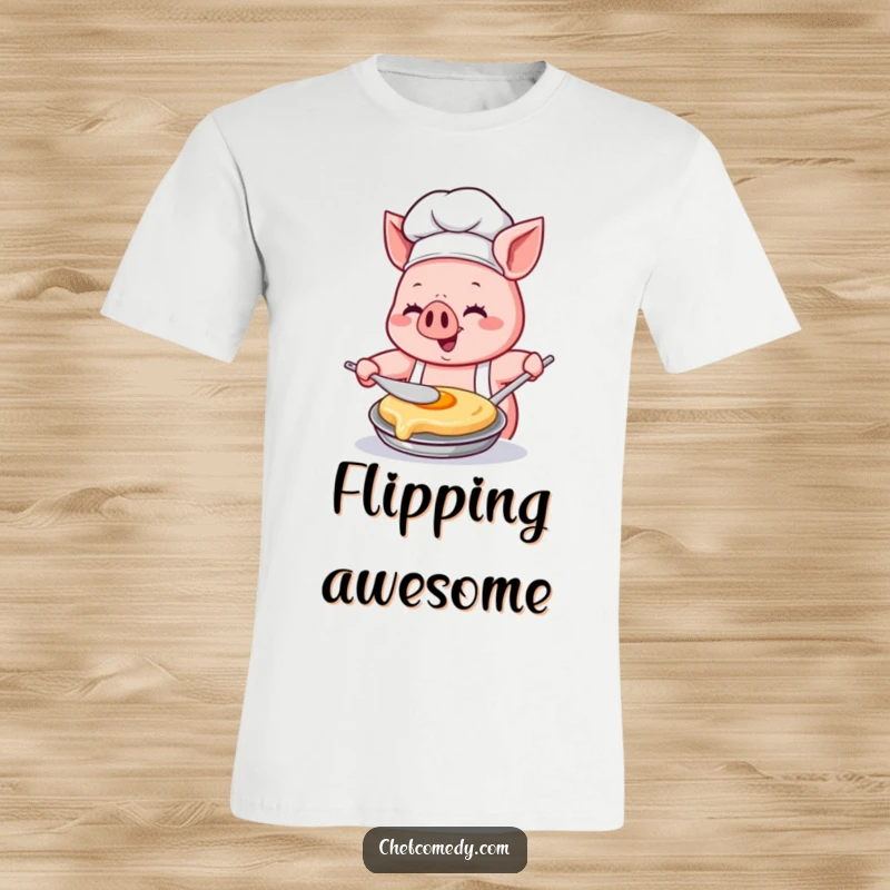 Funny Kawaii pig chef t-shirt, depicted happily flipping a pancake with immense concentration and glee, showcasing culinary passion.