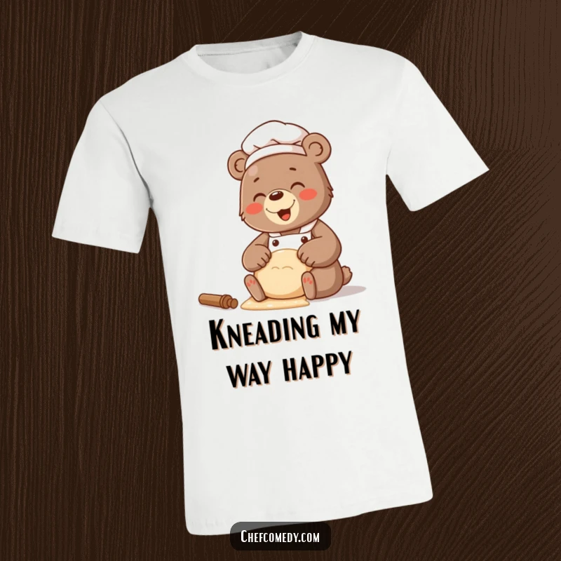 Funny t-shirt depicting a bear chef with a wide, giggling smile while kneading a fluffy mound of dough.